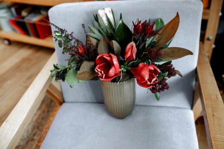 Red Tulip Flowers In Vase On Armchair photo