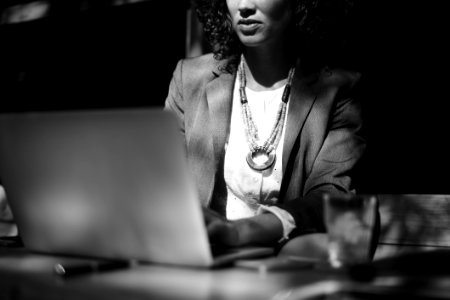 Grayscale Photo Of Woman Using Her Laptop