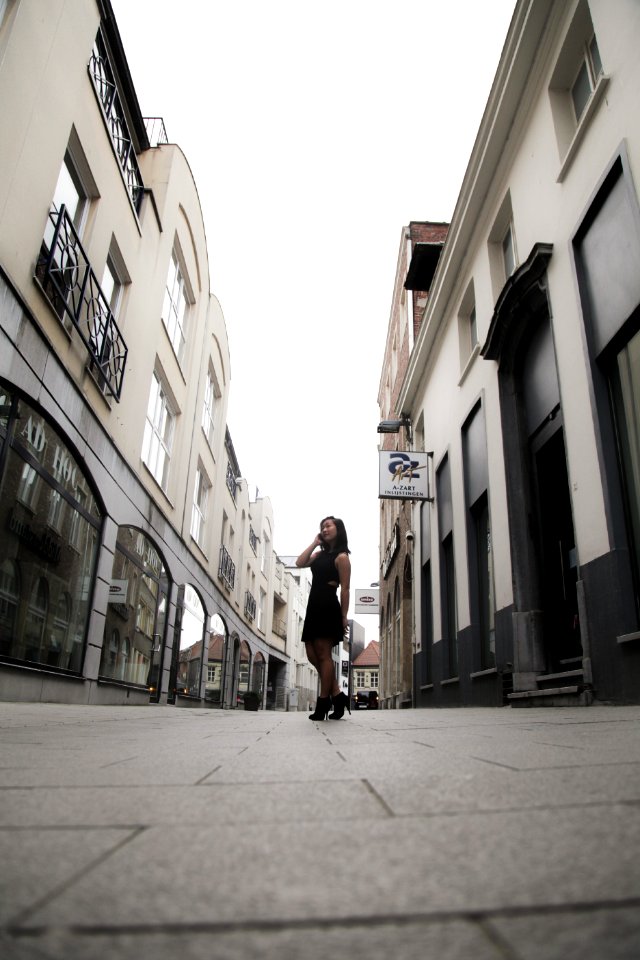 Woman Wearing Black Sleeveless Dress In Between Buildings