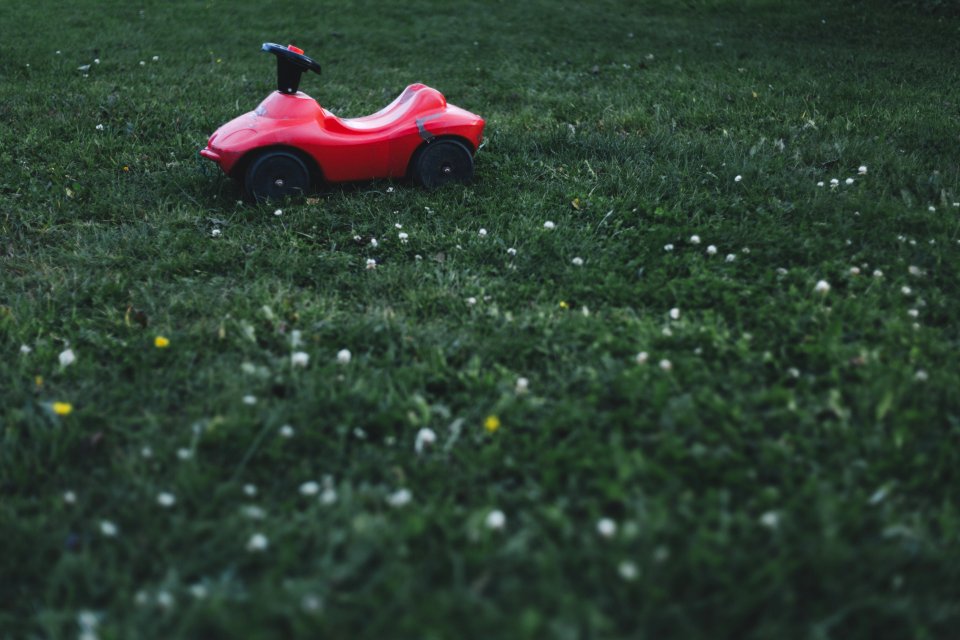 Selective Focus Photography Of Red Ride On Toy