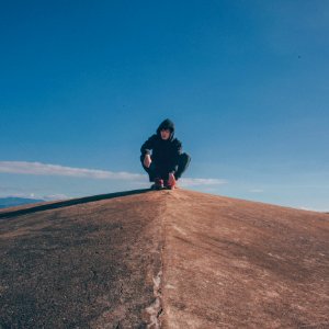 Photo Of Man In The Middle Of Concrete Cliff photo