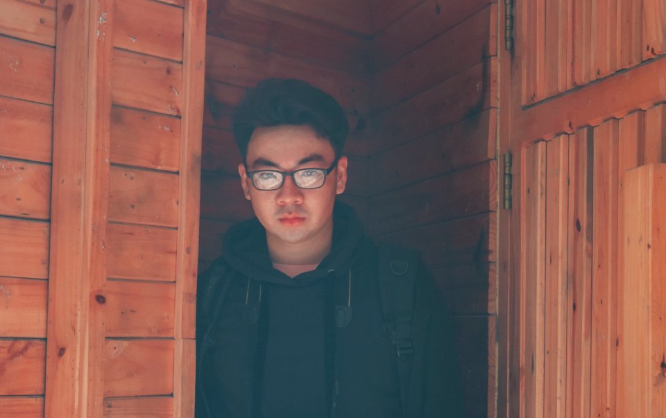 Man Wearing Eyeglasses And Hoodie Jacket In Wooden Room