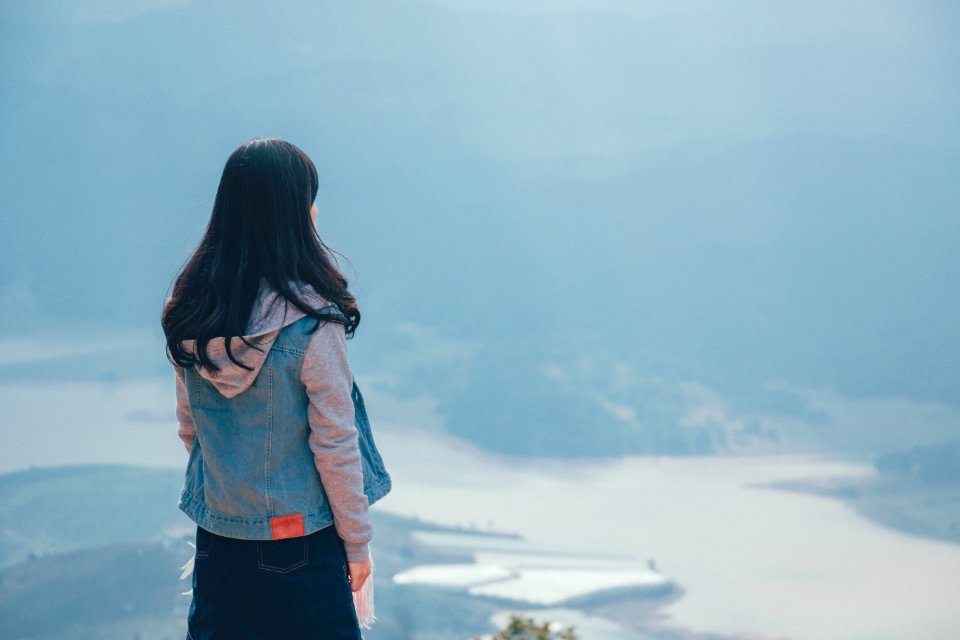 Woman In Gray And Blue Zip-up Hoodie Standing On The Cliff