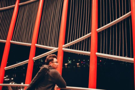 Selective Photography Of Man Leaning On White Metal Railings