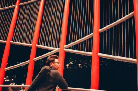 Selective Photography Of Man Leaning On White Metal Railings photo