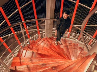 Man Wearing Black Hoodie Standing On Staircase photo