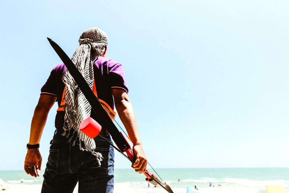 Man Holding Bow In Seashore