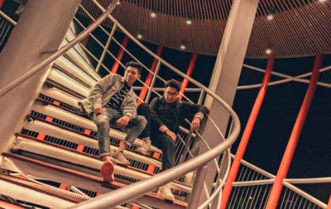 Two Men Sitting On Spiral Stairway