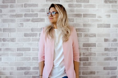 Woman In Pink Cardigan And White Shirt Leaning On The Wall photo