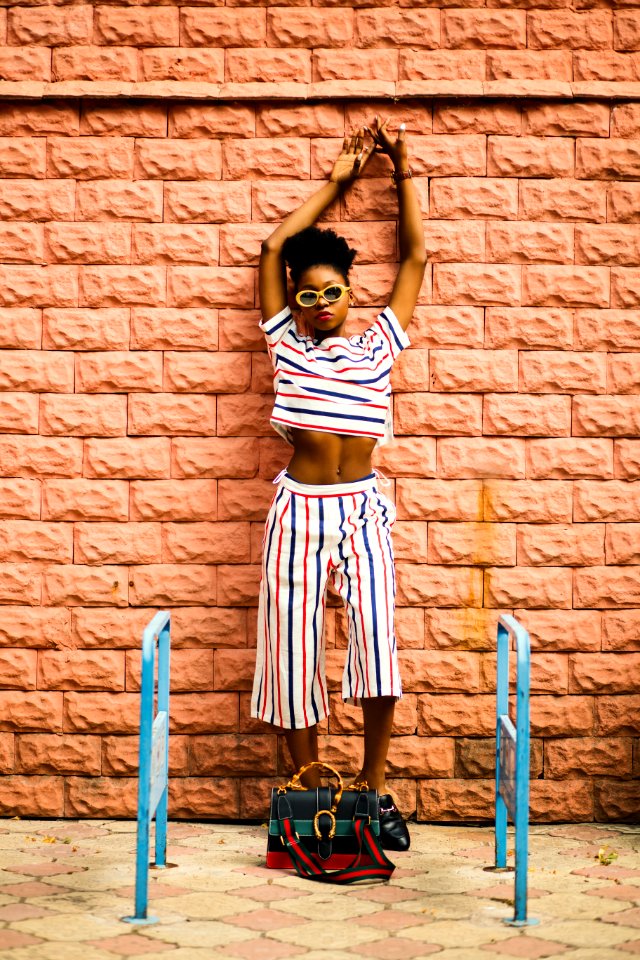 Woman In White Blue And Rd Shirt Leaning On Wall