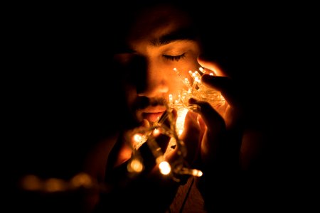 Close-up Photography Of Man Holding Christmas Lights