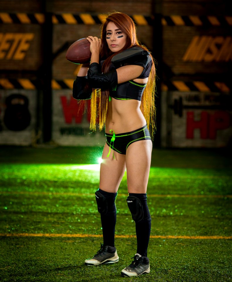Woman Wearing Black-and-green Sports Bra And Pantie Holding Rugby Ball photo
