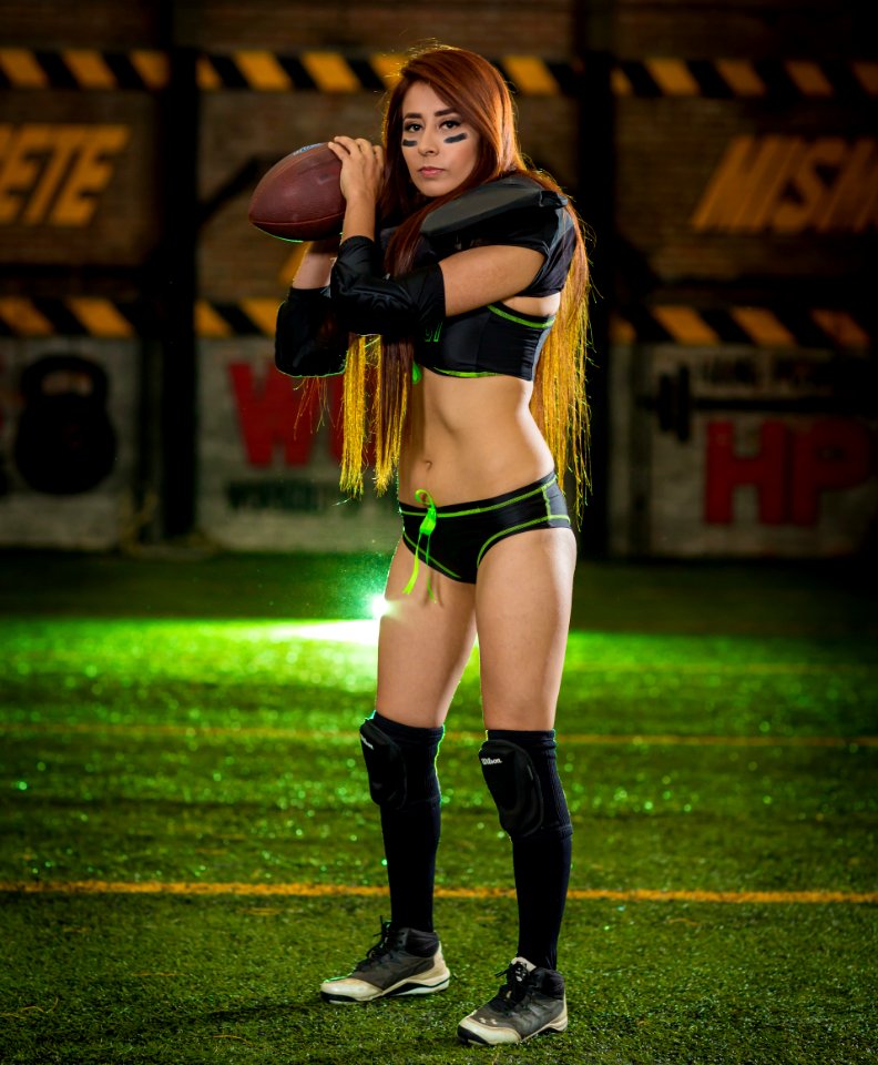 Woman Wearing Black-and-green Sports Bra And Pantie Holding Rugby Ball