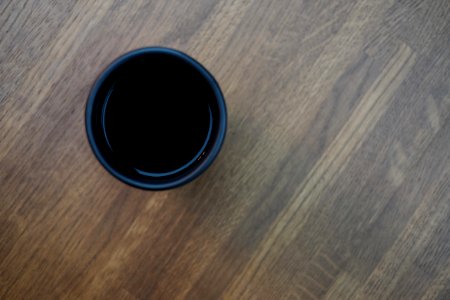 Black Plastic Cup In Top Of Brown Wooden Surface