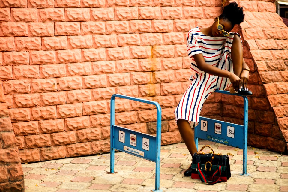 Woman With Striped Romper Sitting On Blue Metal