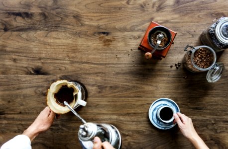 Person Making Coffee Beside Person Holding Cup Of Coffee photo
