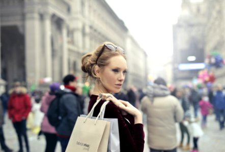 Woman Wearing Maroon Long-sleeved Top Carrying Brown And White Paper Bags In Selective Focus Photography photo