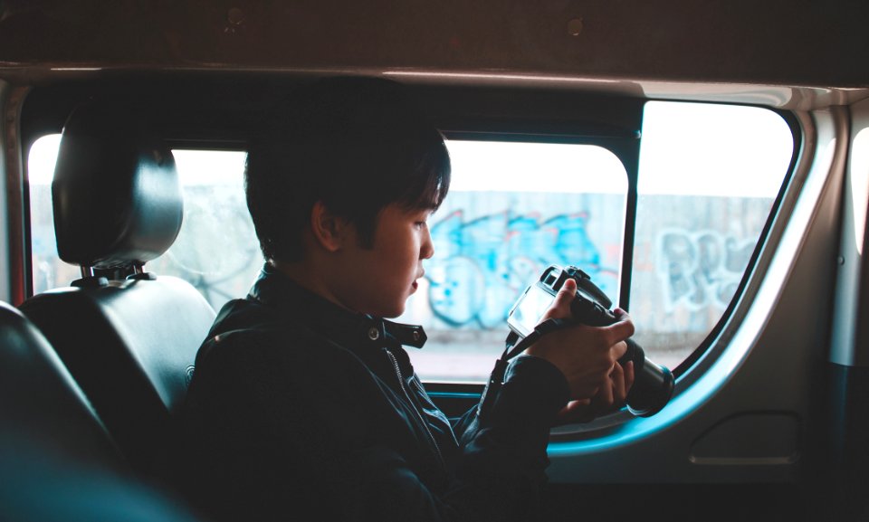 Photo Of Man Holding Dslr Camera Looking At Photos
