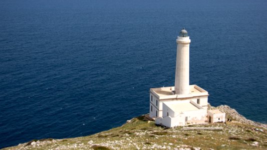 White Lighthouse On Cliff Near Body Of Water photo