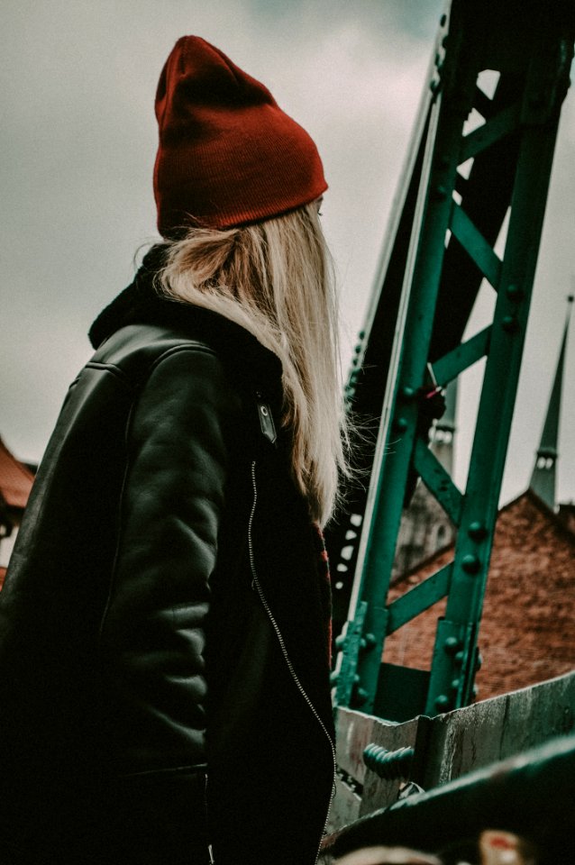 Woman In Black Leather Zip-up Jacket Near Green Metal Stand photo