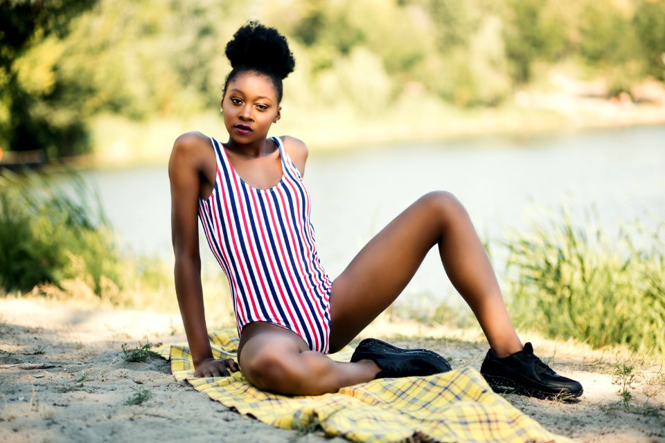 Woman In White Red And Blue Striped One-piece Suit Sitting Near River