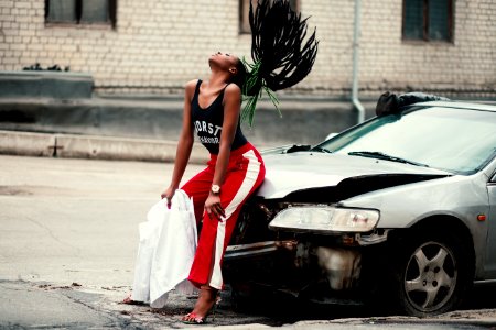 Woman In Black Tank Top Sitting In Front Of Car