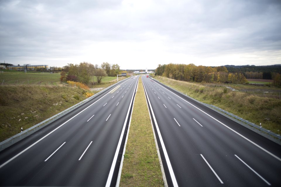 Two Grey Concrete Roads Between Green Grasses