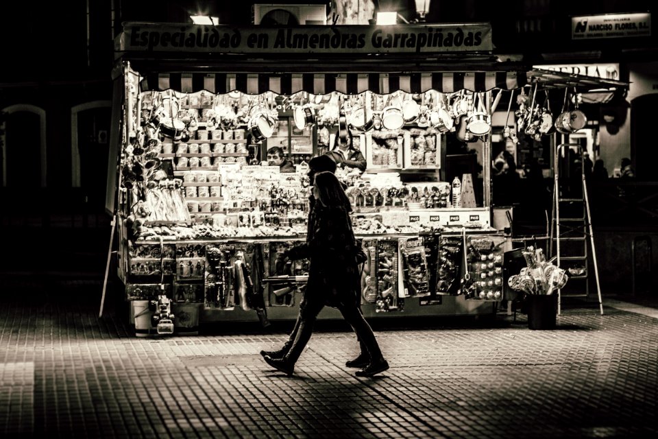 Man And Woman Walking In Front Of Store Greyscale Photo