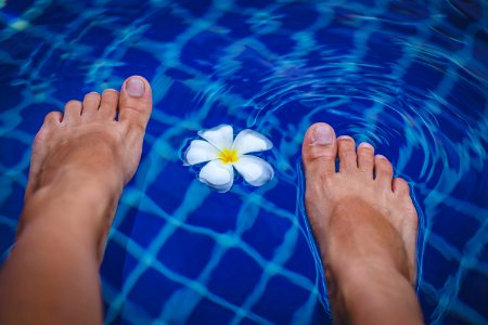 Persons Feet On Swimming Pool photo