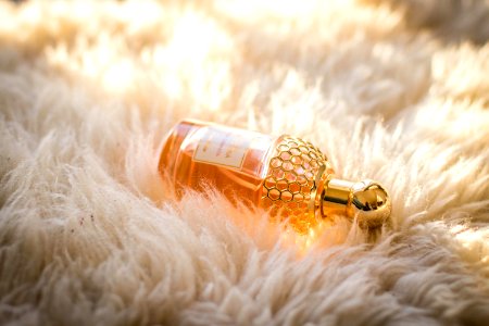 Clear Perfume Bottle On White Fur Textile