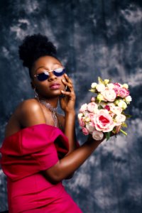 Woman Wearing Sunglasses And Posing For Pic With Flowers photo