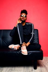 Woman Sitting On Sofa Bed Wearing Sunglasses photo