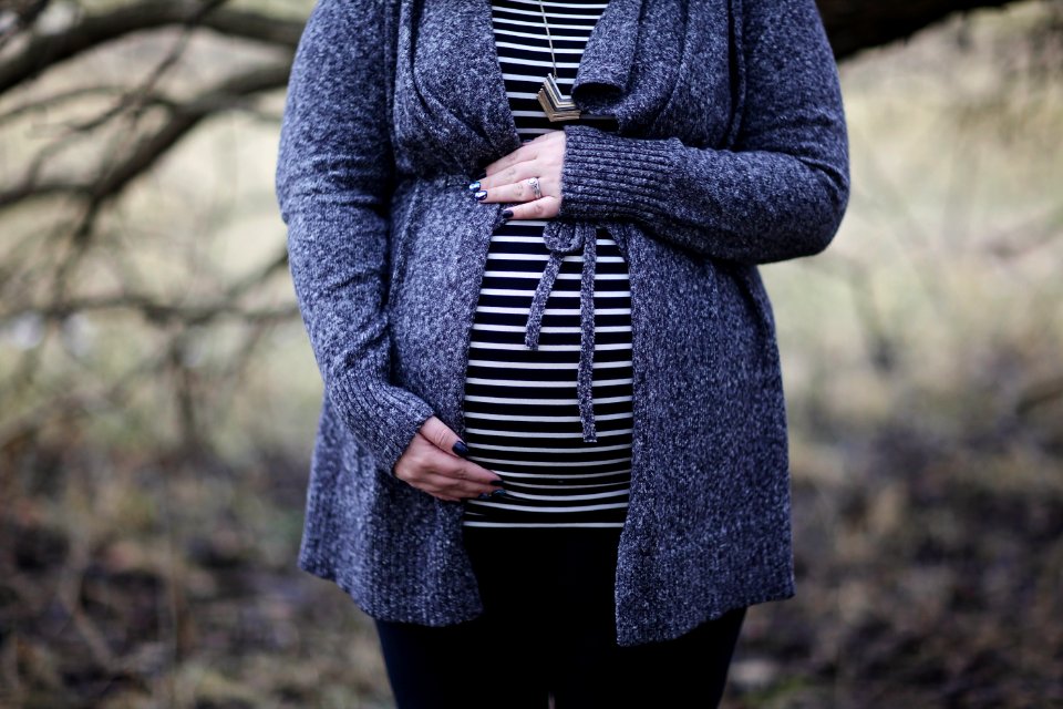 Woman Pregnant In Black And White Striped Shirt Standing Near Bare Tree