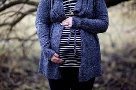 Woman Pregnant In Black And White Striped Shirt Standing Near Bare Tree