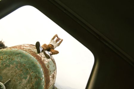 Person Sitting On Green Metal Tank