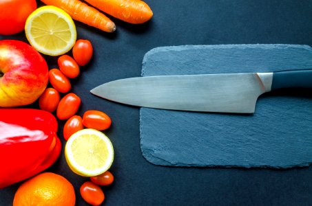 Black Kitchen Knife With Fruits And Vegetable On Table