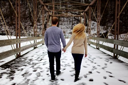Man And Woman Walking On Snow Covered Road photo