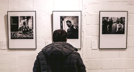 Photo Of Person Standing In Front Of Three Pictures photo