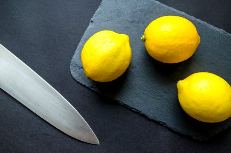 Photo Of Three Lemons On Chopping Board Near Knife photo