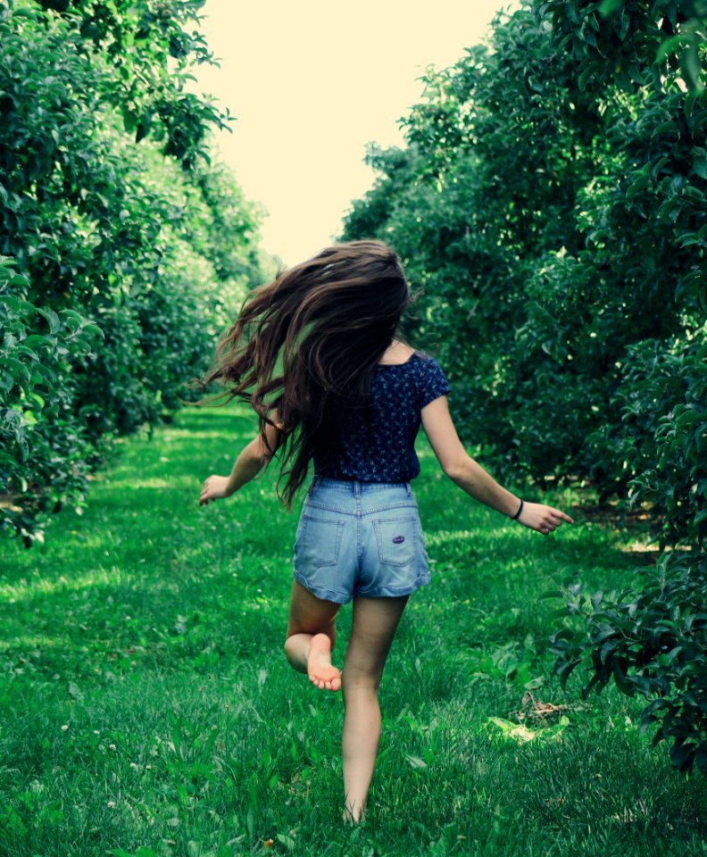 Photo Of A Woman Running On Green Grass