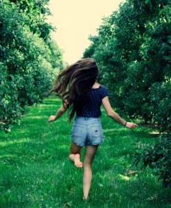 Photo Of A Woman Running On Green Grass