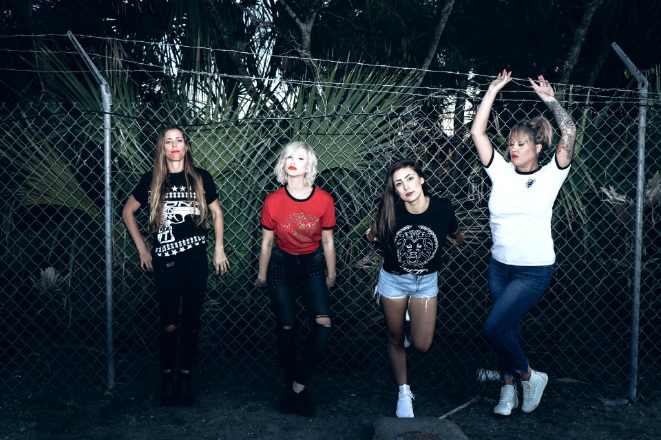Four Women Leaning On Gray Steel Fence