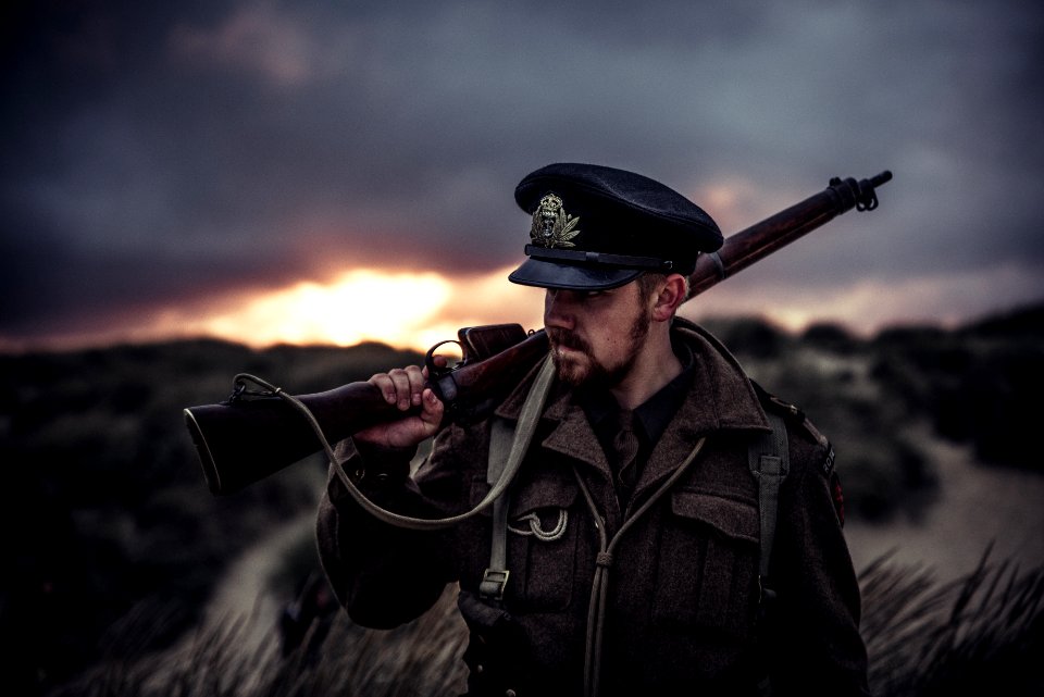Close-Up Photography Of A Man Holding Rifle