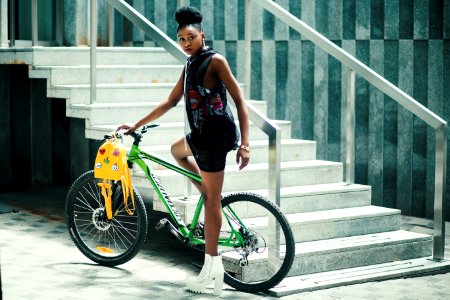 Woman Wearing Black Dress Riding Bicycle Near Stairs photo