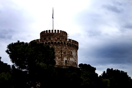 Brown Concrete Tower Near On Green Trees