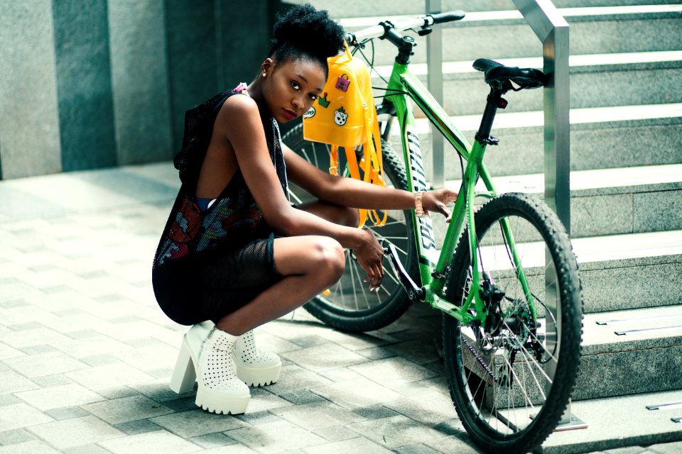 Woman Wearing Black Dress Seating Near Green Bicycle