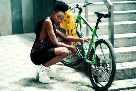 Woman Wearing Black Dress Seating Near Green Bicycle photo