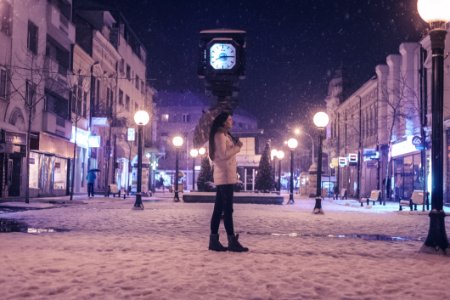 Woman Walking On Street Near Light Post During Winter Season