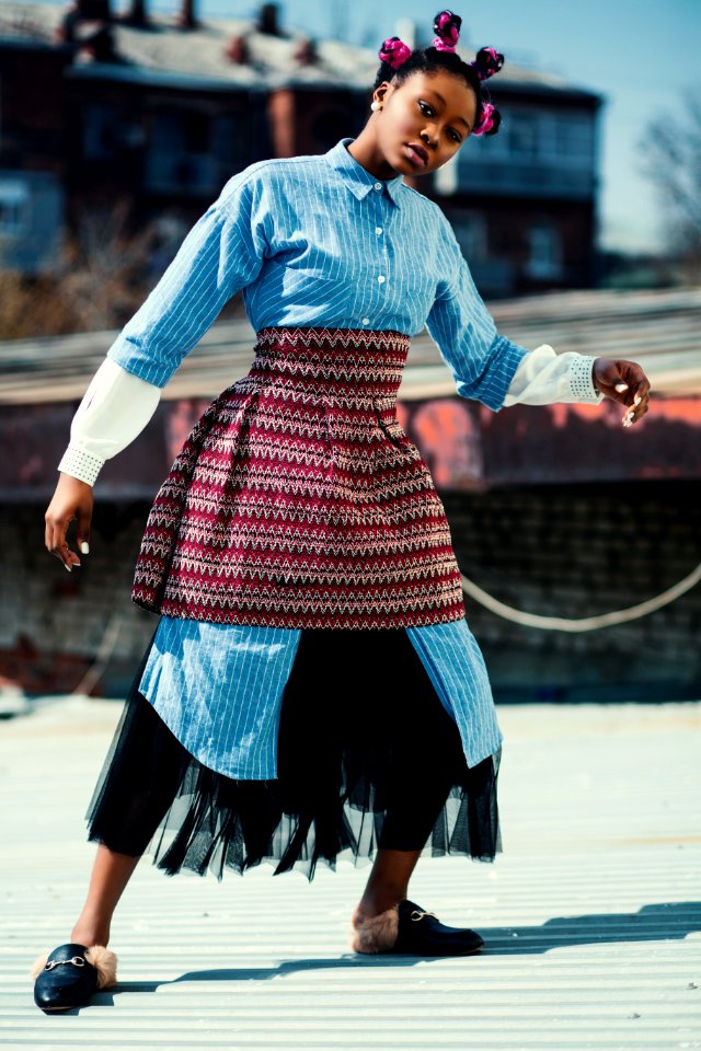 Woman Wearing Blue Long-sleeved Shirt And Red Skirt Standing On Roof