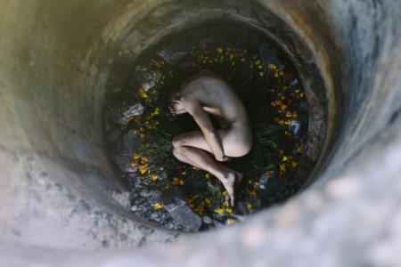 Nude Person Inside Well Laying On Flowers